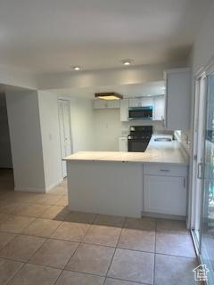745 Three Fountains Cir E Unit 41, Salt Lake City, UT 84107 - kitchen with stove, a peninsula, light countertops, light tile patterned flooring, and recessed lighting