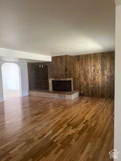 745 Three Fountains Cir E Unit 41, Salt Lake City, UT 84107 - unfurnished living room with a fireplace, wood finished floors, arched walkways, and wood walls