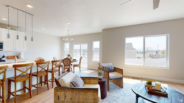 7497 W Sage Slope Way, Herriman, UT 84096 - living room featuring light wood-style floors, recessed lighting, and a chandelier