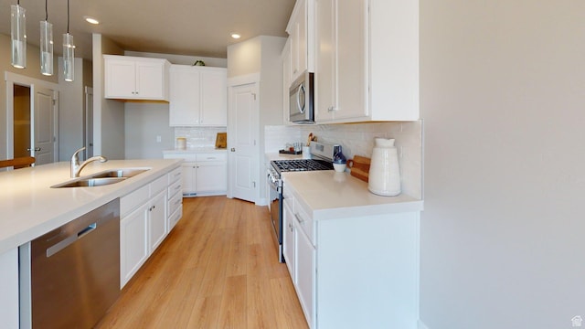 7497 W Sage Slope Way, Herriman, UT 84096 - kitchen with appliances with stainless steel finishes, light wood-style flooring, recessed lighting, decorative light fixtures, and backsplash
