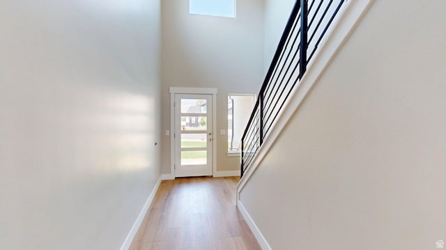 7497 W Sage Slope Way, Herriman, UT 84096 - doorway with stairs, light wood-style flooring, and a towering ceiling