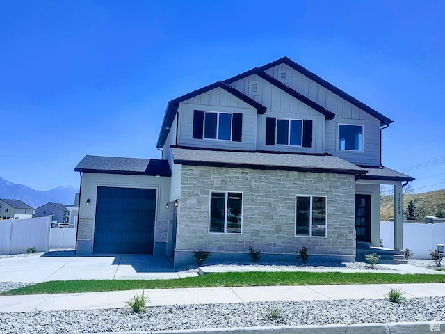 7497 W Sage Slope Way, Herriman, UT 84096 - view of front of home with stone siding, an attached garage, concrete driveway, board and batten siding, and a mountain view