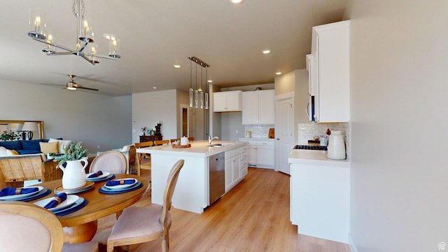 7497 W Sage Slope Way, Herriman, UT 84096 - kitchen featuring stainless steel appliances, a chandelier, open floor plan, decorative backsplash, and hanging light fixtures