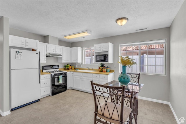1360 E Telegraph Unit 14, Washington, UT 84780 - kitchen featuring black appliances, under cabinet range hood, white cabinetry, light countertops, and plenty of natural light
