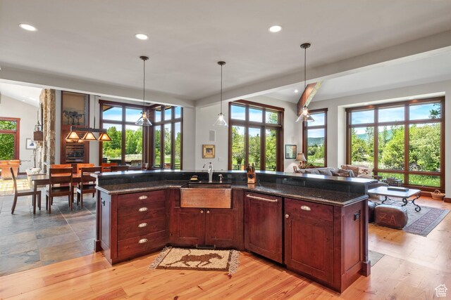 4445 N Millrace Rd, Oakley, UT 84055 - kitchen with plenty of natural light, recessed lighting, dark stone countertops, open floor plan, and lofted ceiling