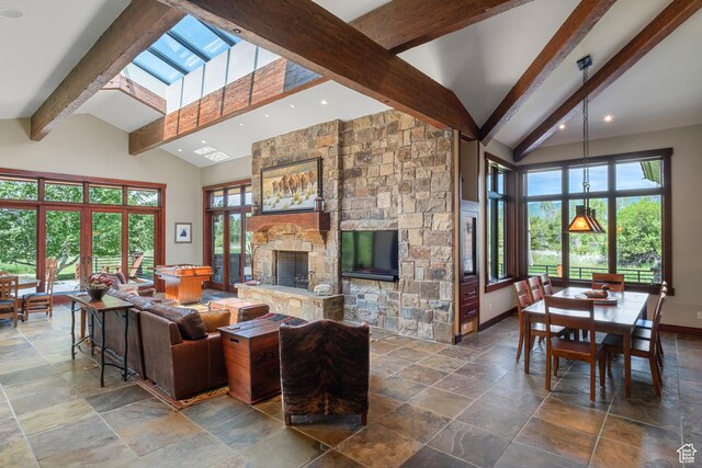 4445 N Millrace Rd, Oakley, UT 84055 - living area with beamed ceiling, stone tile floors, a stone fireplace, high vaulted ceiling, and plenty of natural light