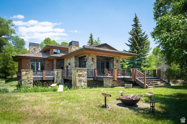 4445 N Millrace Rd, Oakley, UT 84055 - rear view of house with a chimney, a fire pit, stone siding, and a lawn