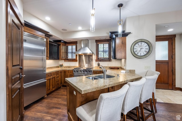 1825 Three Kings Dr Unit 703, Park City, UT 84060 - kitchen with wall chimney range hood, high end appliances, a peninsula, a kitchen bar, and hanging light fixtures