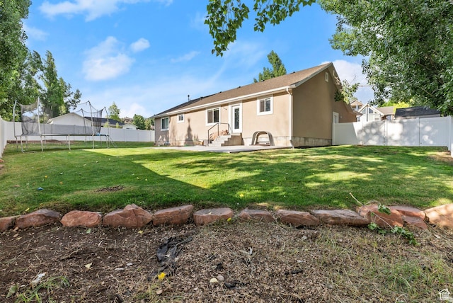1235 N Valley Hills Blvd, Heber City, UT 84032 - back of house featuring a trampoline, a fenced backyard, stucco siding, and a patio