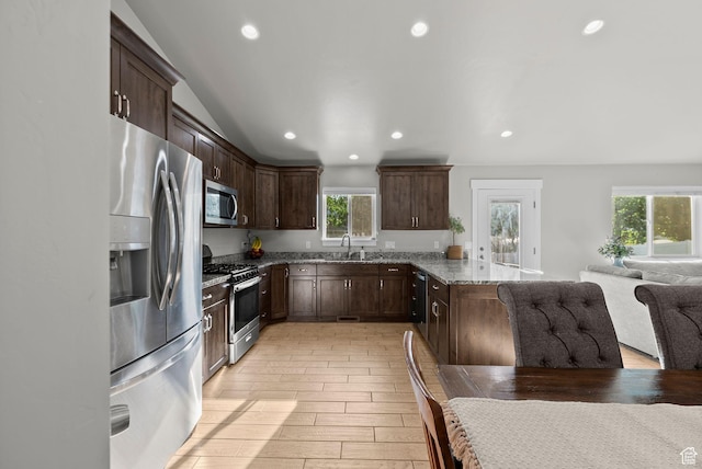 1235 N Valley Hills Blvd, Heber City, UT 84032 - kitchen with stainless steel appliances, stone countertops, a peninsula, open floor plan, and dark brown cabinets