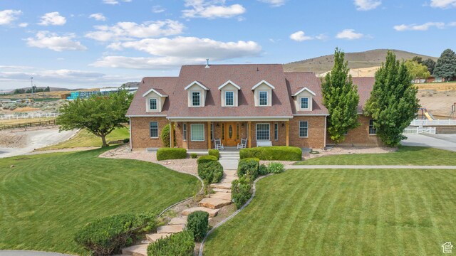 11508 S 5825 W, Payson, UT 84651 - new england style home with brick siding, covered porch, and a front lawn