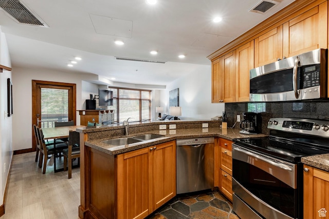 3720 N Sundial Ct Unit B322, Park City, UT 84098 - kitchen with appliances with stainless steel finishes, a peninsula, recessed lighting, plenty of natural light, and brown cabinets