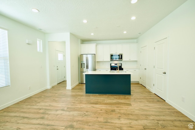 6669 W Skip Rock Rd, South Jordan, UT 84009 - kitchen featuring appliances with stainless steel finishes, recessed lighting, a kitchen island with sink, white cabinetry, and light wood-style floors