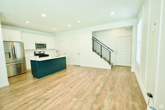 6669 W Skip Rock Rd, South Jordan, UT 84009 - kitchen with appliances with stainless steel finishes, a center island with sink, recessed lighting, white cabinetry, and light wood-type flooring