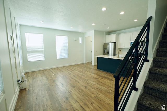 6669 W Skip Rock Rd, South Jordan, UT 84009 - unfurnished living room with recessed lighting, stairway, and light wood finished floors