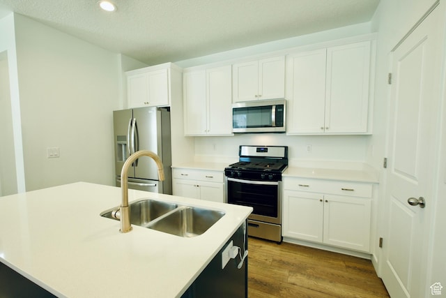 6669 W Skip Rock Rd, South Jordan, UT 84009 - kitchen featuring appliances with stainless steel finishes, dark wood-style flooring, white cabinetry, a textured ceiling, and light countertops
