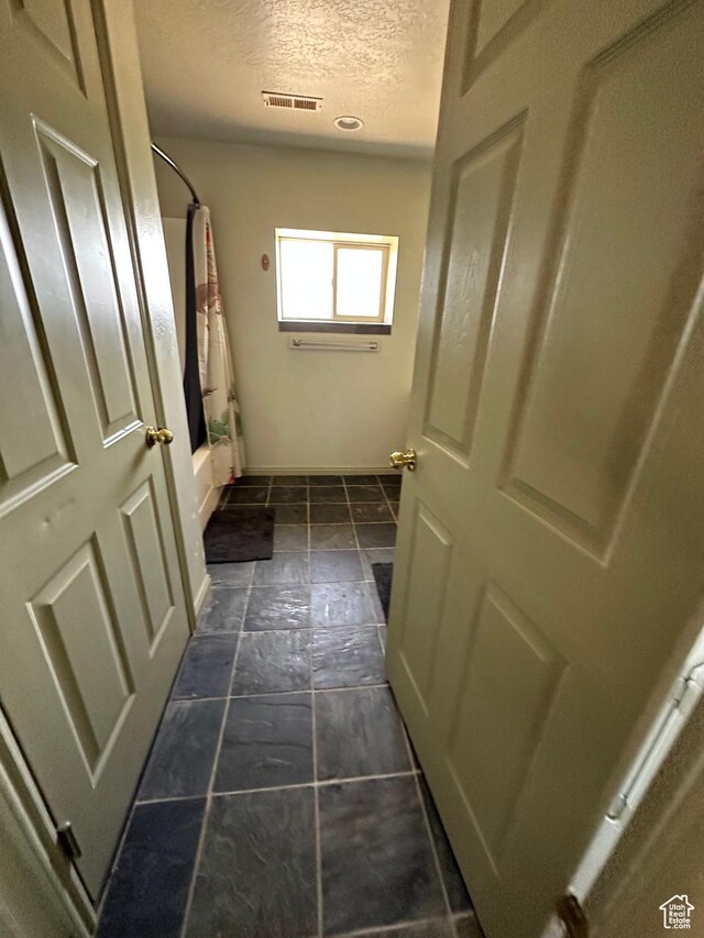280 W Center St, Sterling, UT 84665 - full bath featuring a textured ceiling, shower / bath combo, and stone tile floors