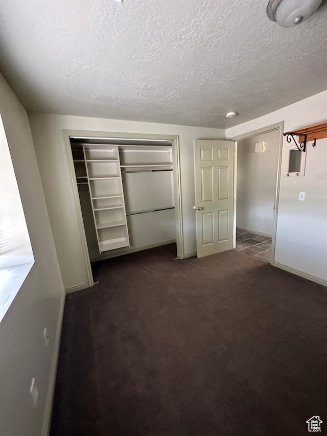 280 W Center St, Sterling, UT 84665 - unfurnished bedroom with a textured ceiling, a closet, and dark carpet