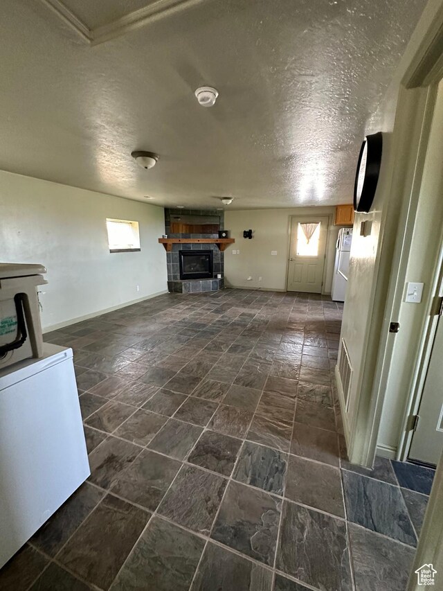 280 W Center St, Sterling, UT 84665 - unfurnished living room with a textured ceiling and a fireplace
