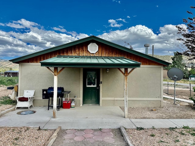 280 W Center St, Sterling, UT 84665 - view of front facade with stucco siding, a metal roof, and a patio