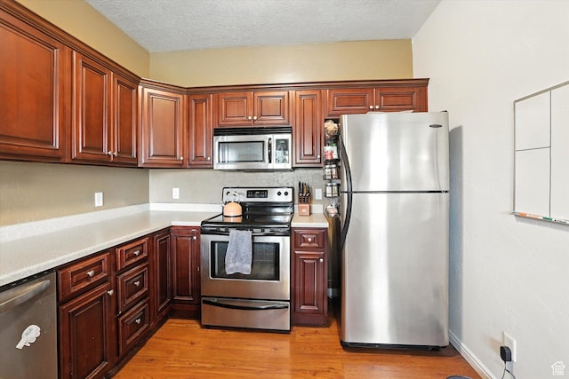 487 W 1490 N Unit 106, Logan, UT 84341 - kitchen with appliances with stainless steel finishes, light countertops, light wood-style flooring, and a textured ceiling