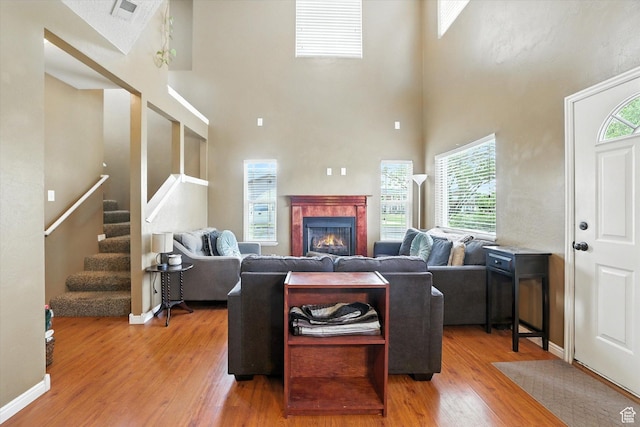 487 W 1490 N Unit 106, Logan, UT 84341 - living area featuring wood finished floors, a towering ceiling, stairway, and a tiled fireplace