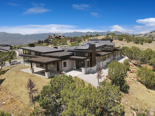 3057 E Corral Peak Cir Unit 147, Heber City, UT 84032 - back of property with a patio area, a mountain view, and stone siding