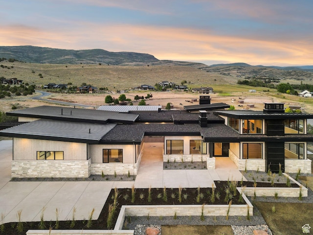 3057 E Corral Peak Cir Unit 147, Heber City, UT 84032 - back of house featuring stone siding, a mountain view, and a vegetable garden