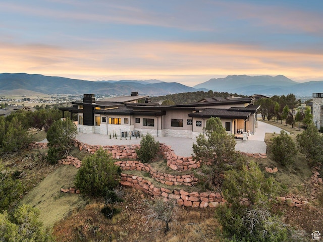 3057 E Corral Peak Cir Unit 147, Heber City, UT 84032 - rear view of property with a patio, a mountain view, stucco siding, and a chimney