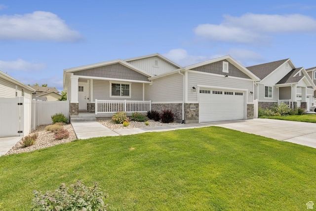 4913 W Olympic View Dr S, Kearns, UT 84118 - craftsman-style house featuring stone siding, covered porch, an attached garage, and driveway