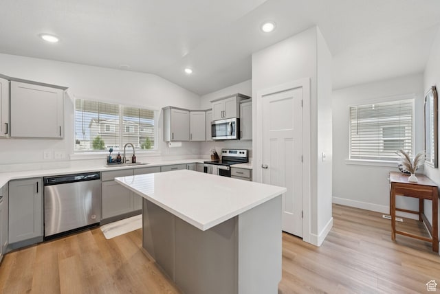 4913 W Olympic View Dr S, Kearns, UT 84118 - kitchen with stainless steel appliances, gray cabinetry, light countertops, vaulted ceiling, and light wood-style floors