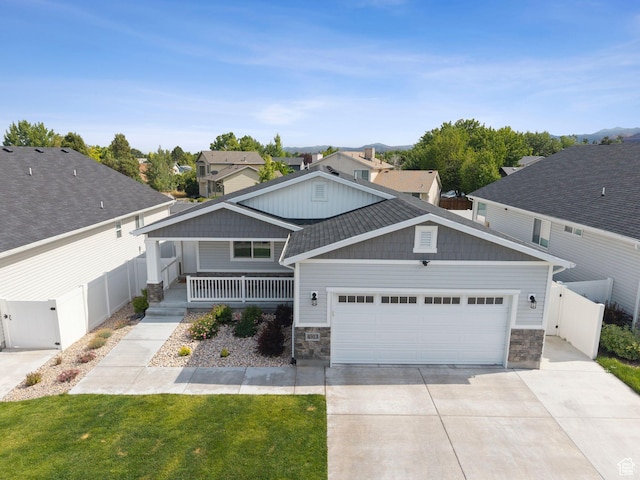 4913 W Olympic View Dr S, Kearns, UT 84118 - craftsman-style home featuring stone siding, a garage, concrete driveway, and a gate