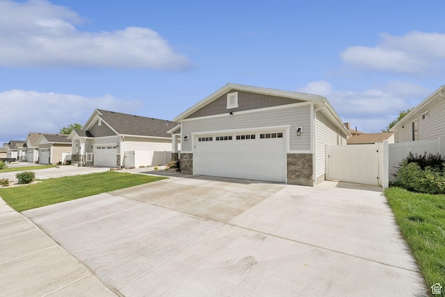 4913 W Olympic View Dr S, Kearns, UT 84118 - craftsman-style house featuring concrete driveway, an attached garage, stone siding, and a gate