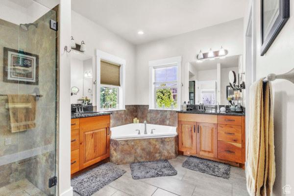 2330 E Meadow Lark Ln, North Logan, UT 84341 - bathroom featuring two vanities, a shower stall, a bath, tile patterned floors, and recessed lighting