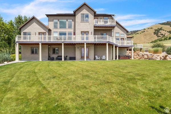 2330 E Meadow Lark Ln, North Logan, UT 84341 - rear view of house featuring stucco siding and a lawn