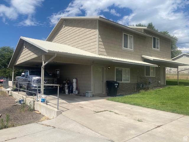 526 W 200 S, Brigham City, UT 84302 - view of front facade with an attached carport, driveway, a front yard, a metal roof, and stone siding