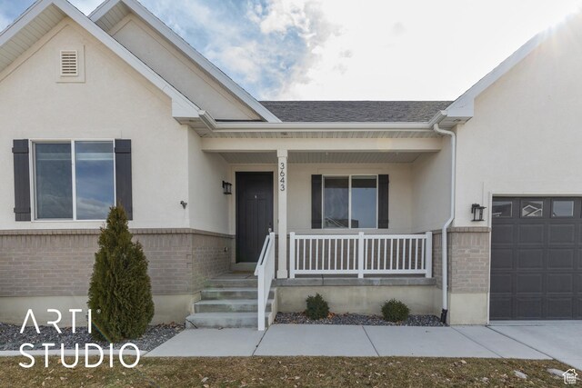 3643 W 650 N, Layton, UT 84041 - view of front of house featuring a porch, brick siding, stucco siding, and a garage