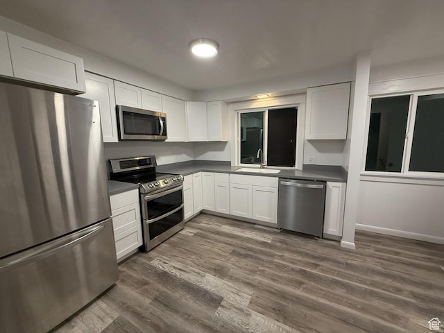 318 E 100 N, Brigham City, UT 84302 - kitchen featuring stainless steel appliances, dark countertops, white cabinets, and dark wood finished floors