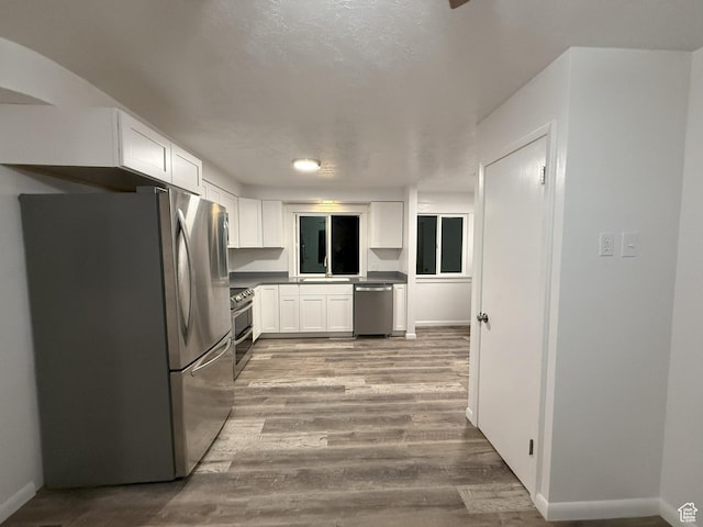 318 E 100 N, Brigham City, UT 84302 - kitchen with stainless steel appliances, white cabinets, and light wood-style flooring