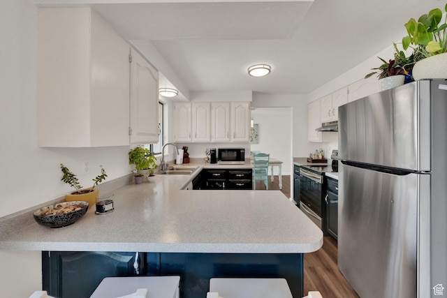 1888 W 7265 S, West Jordan, UT 84084 - kitchen featuring appliances with stainless steel finishes, a peninsula, light countertops, and wood finished floors