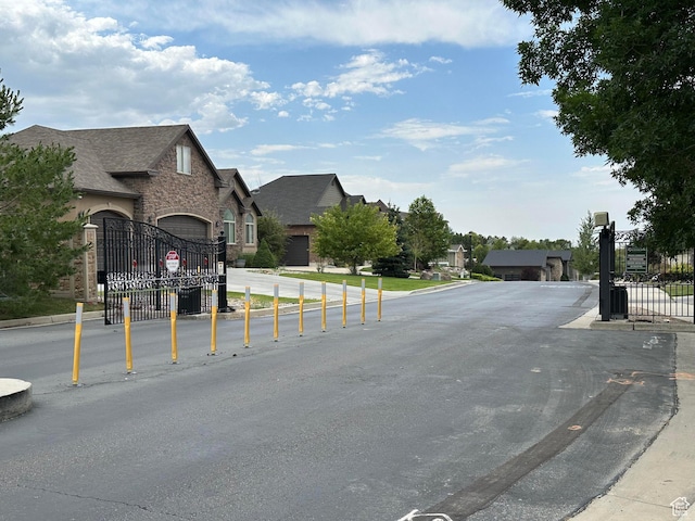 10227 Mystic Brook Way S, South Jordan, UT 84095 - view of asphalt street featuring a gate, a residential view, a gated entry, and traffic signs