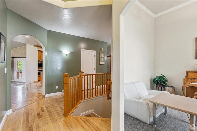 2602 W 11625 S, Riverton, UT 84095 - hall featuring arched walkways, light wood finished floors, an upstairs landing, and ornamental molding