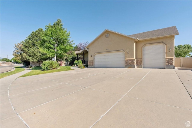 2602 W 11625 S, Riverton, UT 84095 - view of front of property featuring an attached garage, concrete driveway, stucco siding, and stone siding
