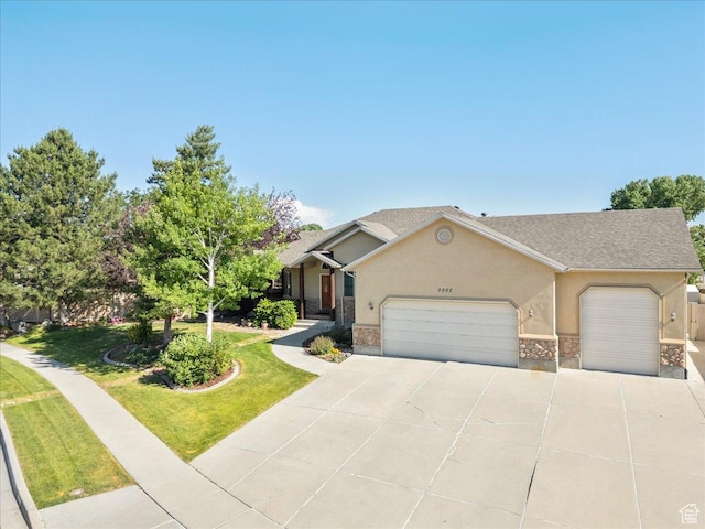 2602 W 11625 S, Riverton, UT 84095 - view of front facade with an attached garage, concrete driveway, stucco siding, a front yard, and stone siding