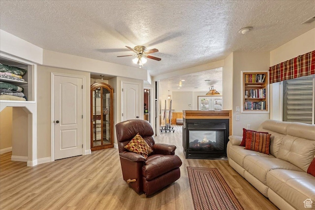 2602 W 11625 S, Riverton, UT 84095 - living area featuring light wood-type flooring, a textured ceiling, a multi sided fireplace, and a ceiling fan