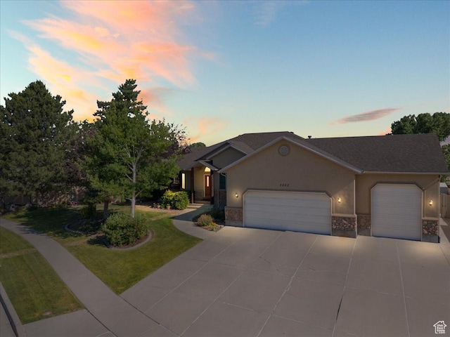 2602 W 11625 S, Riverton, UT 84095 - ranch-style house featuring an attached garage, driveway, stucco siding, a lawn, and stone siding