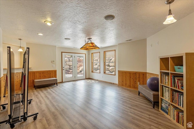 2602 W 11625 S, Riverton, UT 84095 - living area featuring wainscoting, wooden walls, a textured ceiling, wood finished floors, and french doors
