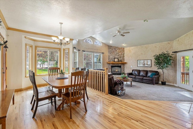 2602 W 11625 S, Riverton, UT 84095 - dining space featuring light wood finished floors, lofted ceiling, a textured ceiling, a stone fireplace, and ceiling fan