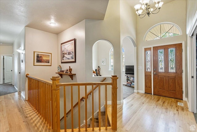 2602 W 11625 S, Riverton, UT 84095 - entryway featuring light wood-type flooring, a chandelier, and arched walkways