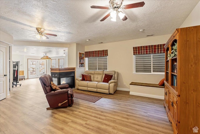 2602 W 11625 S, Riverton, UT 84095 - living room featuring a ceiling fan, a textured ceiling, a multi sided fireplace, and light wood finished floors